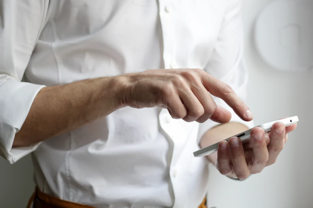 Mann tippt mit Zeigefinger auf Handyscreen