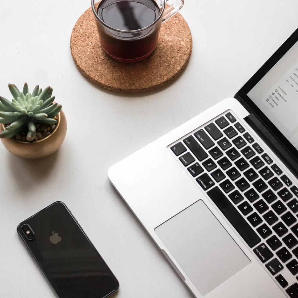 Laptop Apple, iPhone, Kaffee und Pflanze